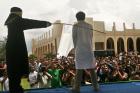 A Sharia law official whips a man convicted of a crime with a rattan stick during a public caning in Jantho, Aceh province, Indonesia, Friday, April 8, 2011.