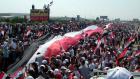 Thousands of Syrians carry a gigantic 16,000-meter Syrian flag during a demonstration in the Mediterranean city of Latakia on Sunday in support of President Bashar Assad. (AP)