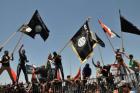 Masked Sunni protesters wave Islamist flags while others chant slogans at an anti-government rally in Fallujah, Iraq, Friday, April 26, 2013. Iraqi soldiers backed by tanks retook control of a Sunni town north of Baghdad on Friday after gunmen withdrew without a fight, although violence continued in other parts of the country. The Sunni gunmen had seized Suleiman Beg on Thursday after a firefight with security forces, one in a string of similar incidents that have killed more than 150 people in