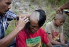 Police shave the hair of detained Indonesian punks at a police school in Aceh province. Sharia police are "morally rehabilitating" more than 60 young punk rock fans, saying the youths tarnish the province's Islamic image, by forcing to have their hair cut, bathe in a lake, change clothes and pray. AFP Photo