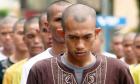 Indonesian punk rock fans, their head shaved clean, stand in line before prayer at the police school in Aceh Besar, Indonesia. Photograph: Heri Juanda/AP